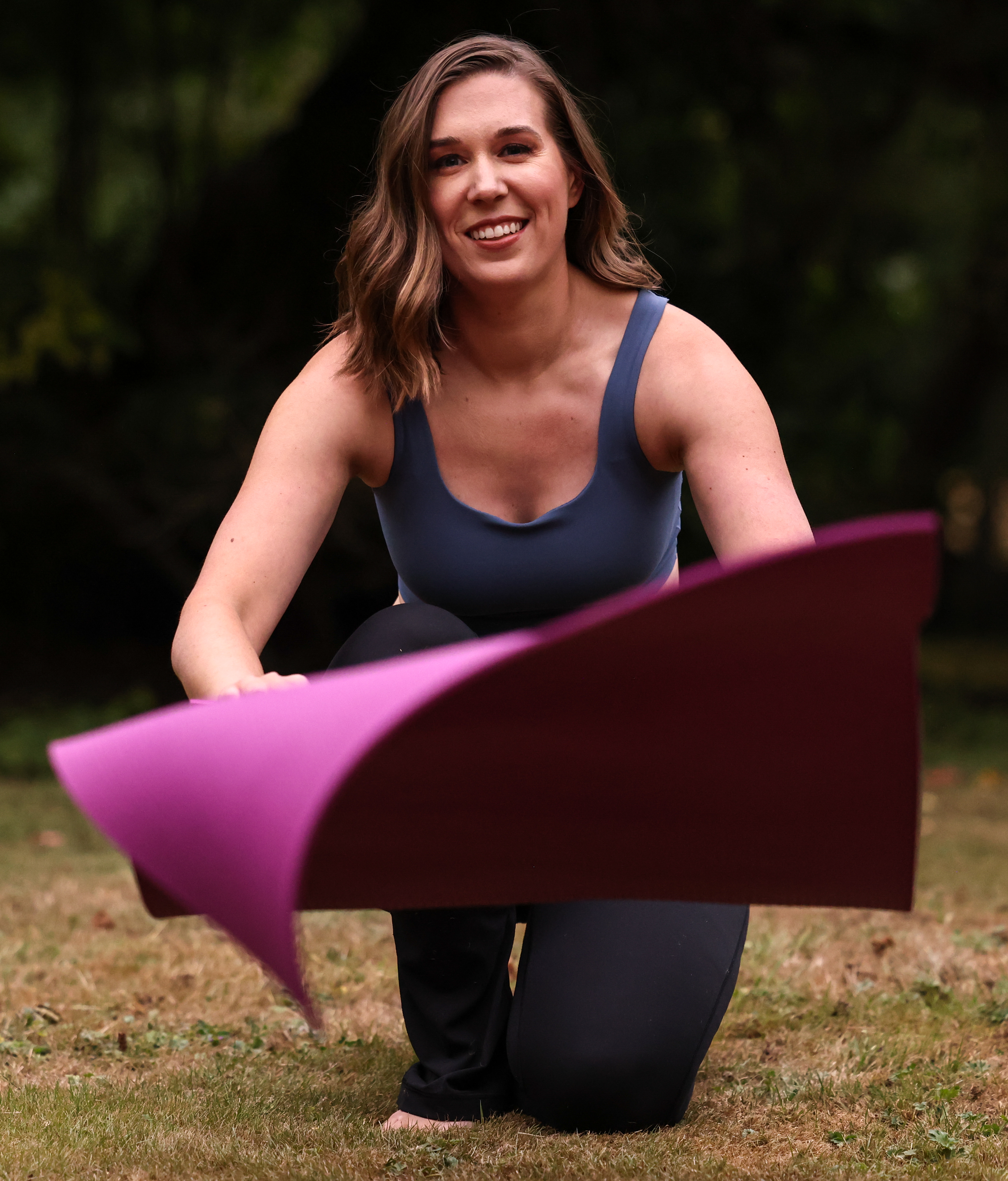 A yoga woman rolling out her yoga mat